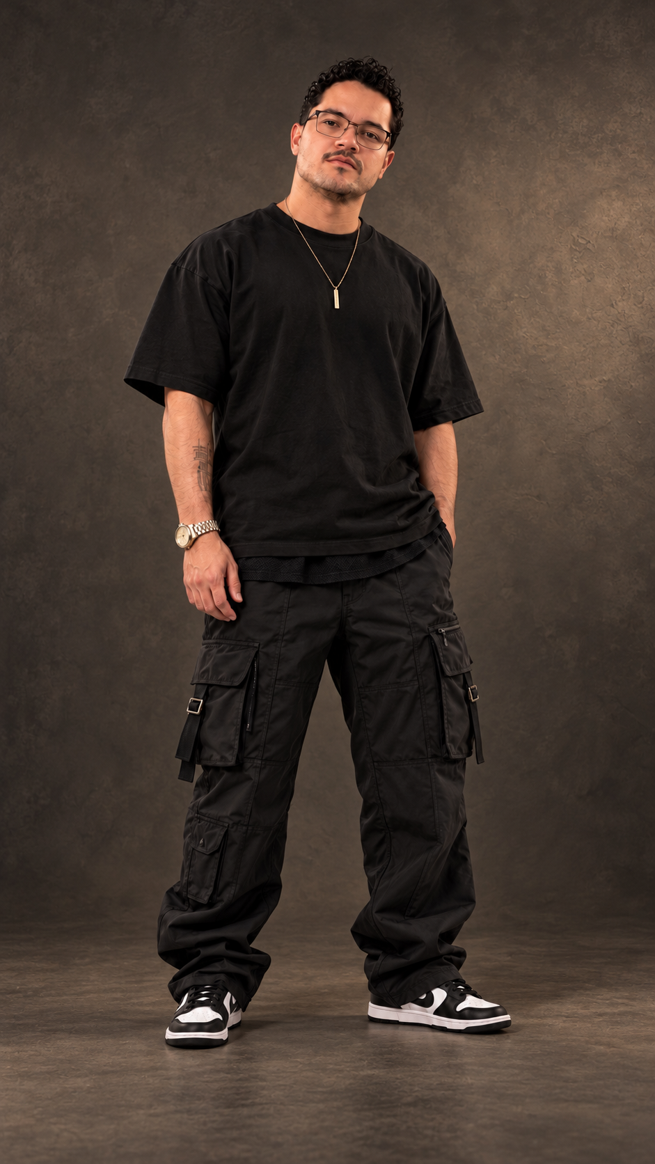 ARYUN em retrato de divulgação, com look preto oversized e fundo grafite